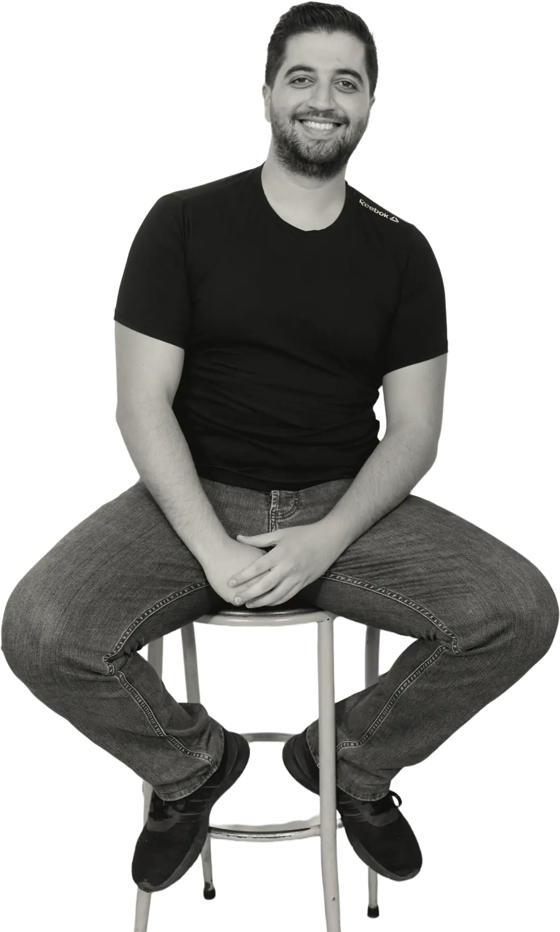Sergio Aoun sitting on a stool, smiling
